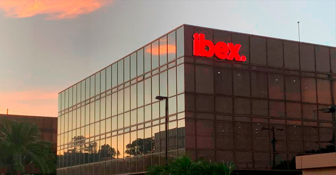 Rotulo luminoso rojo Ibex sobre fachada de vidrio en Ofiplaza El Retiro Letras de acrilico e iluminacion led
