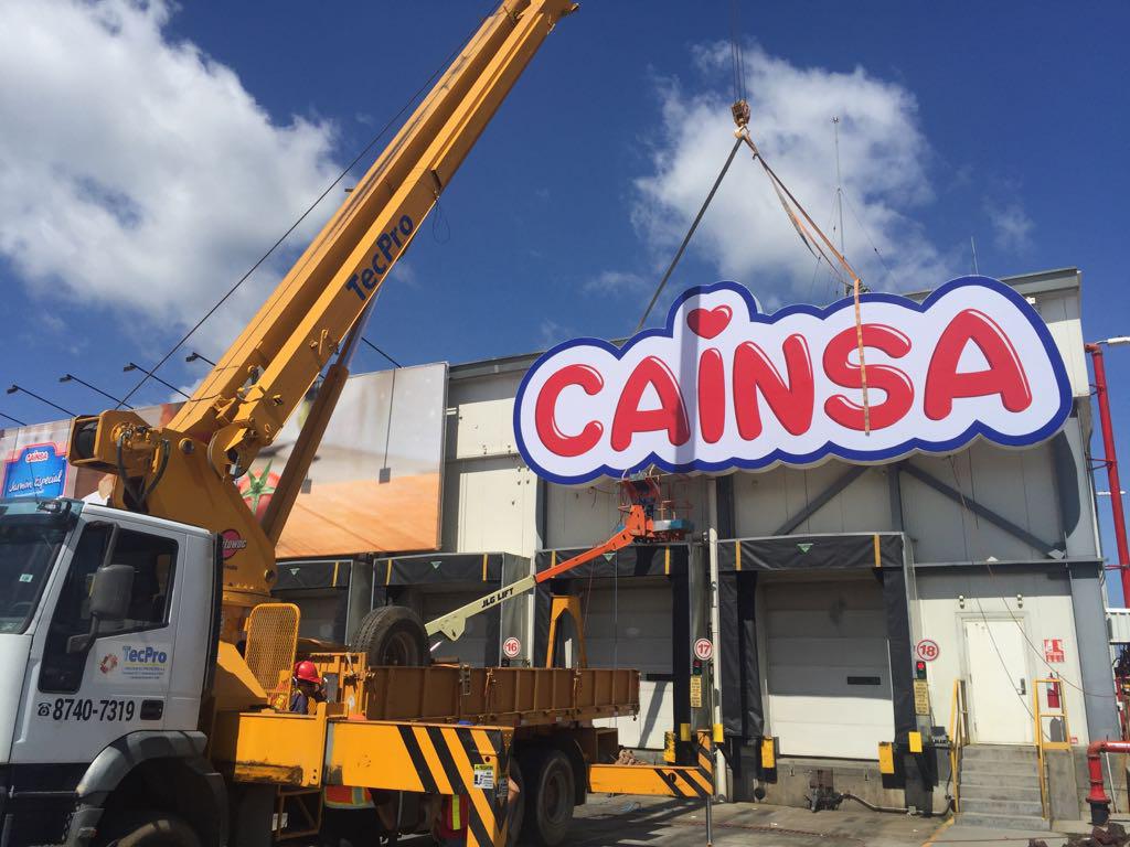 Grua instalando rotulo luminoso de CAINSA fabricado por ALFATEC, en plantel de Cargill